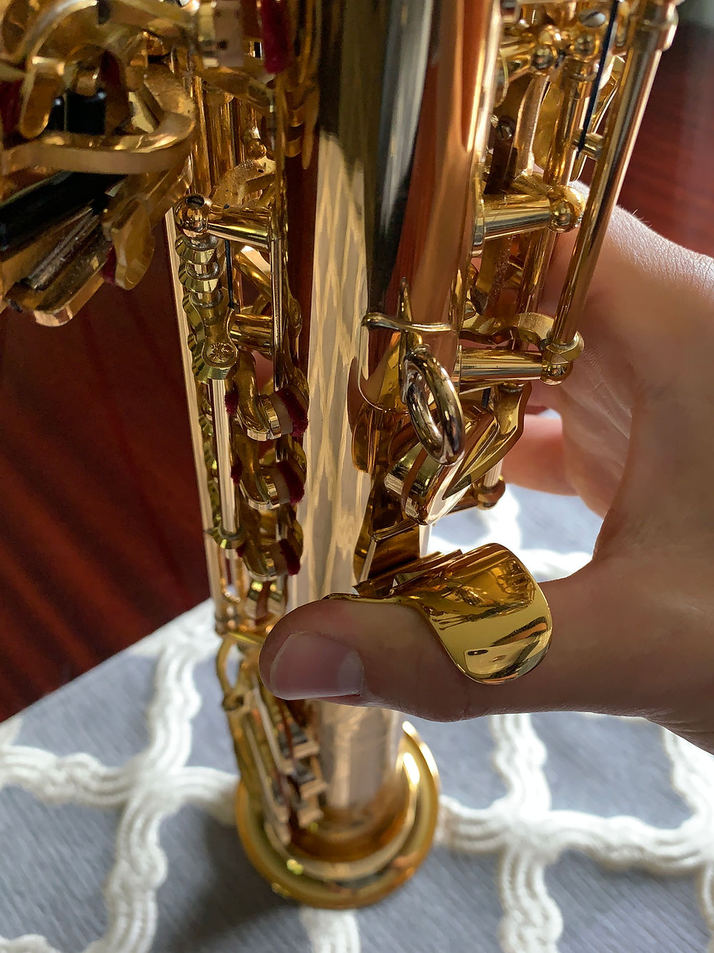 A right thumb placed into a saxophone thumb hook using the LAGAN wrist saver for soprano saxophone.