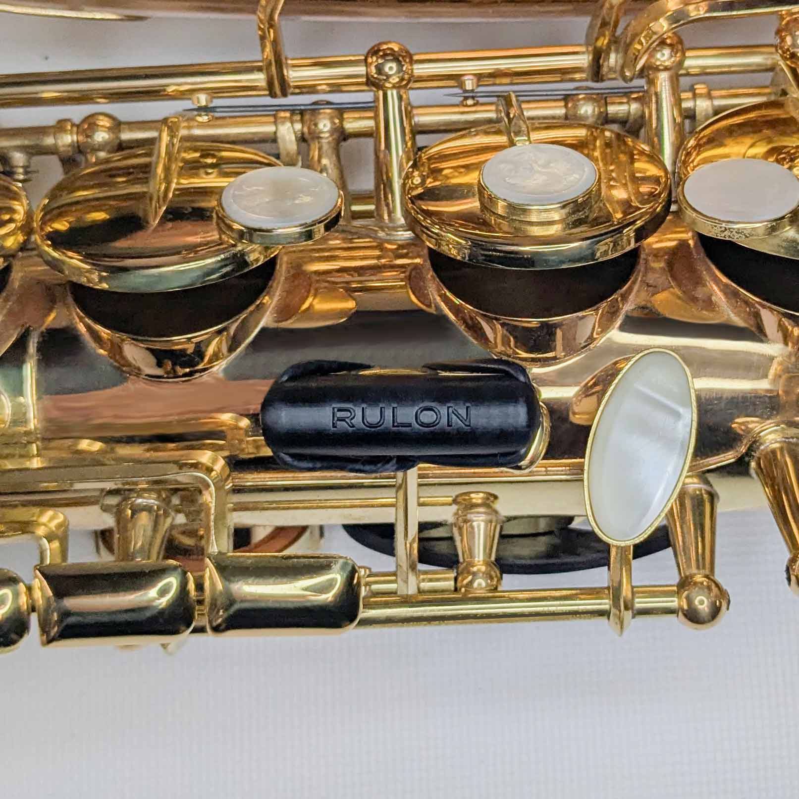 A close up image showing the RULON Saxophone Key Booster for High F#. It raises the key height up to meet your hand and make playing more comfortable and easy.
